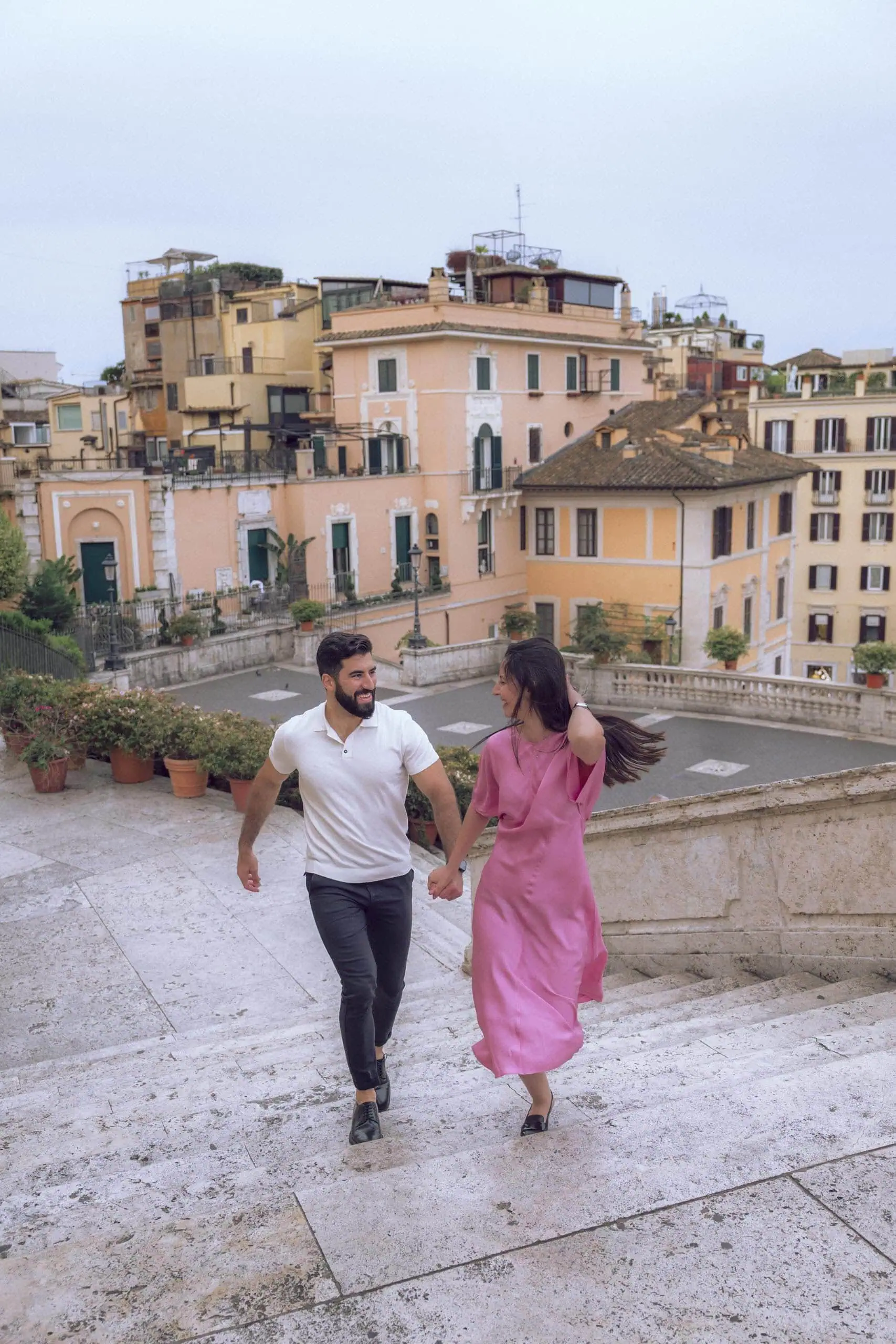 Couple holding hands running up spanish steps Rome - Rome by Finzi