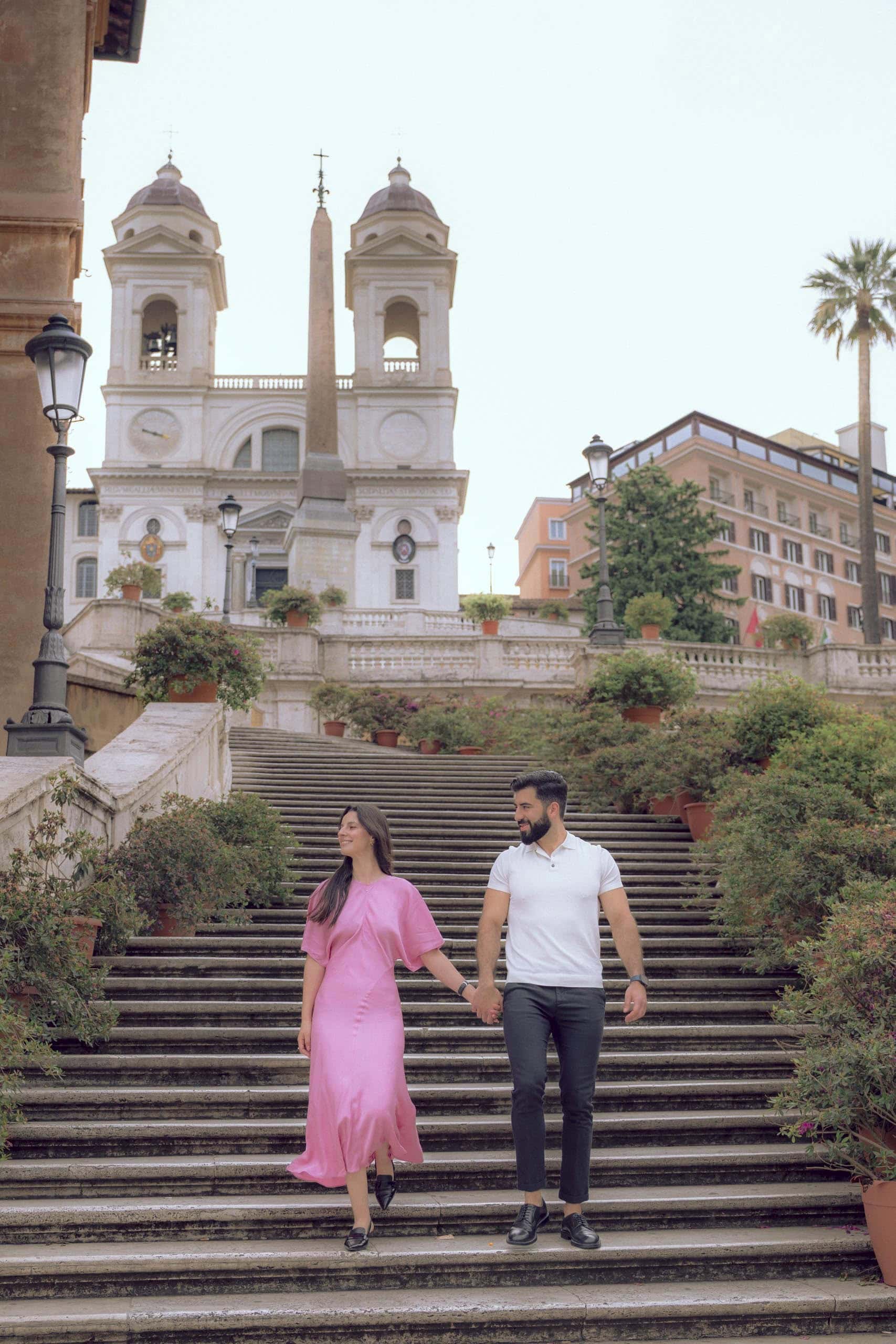 Couple holding hands walking spanish steps - couples photography in Rome by Finzi