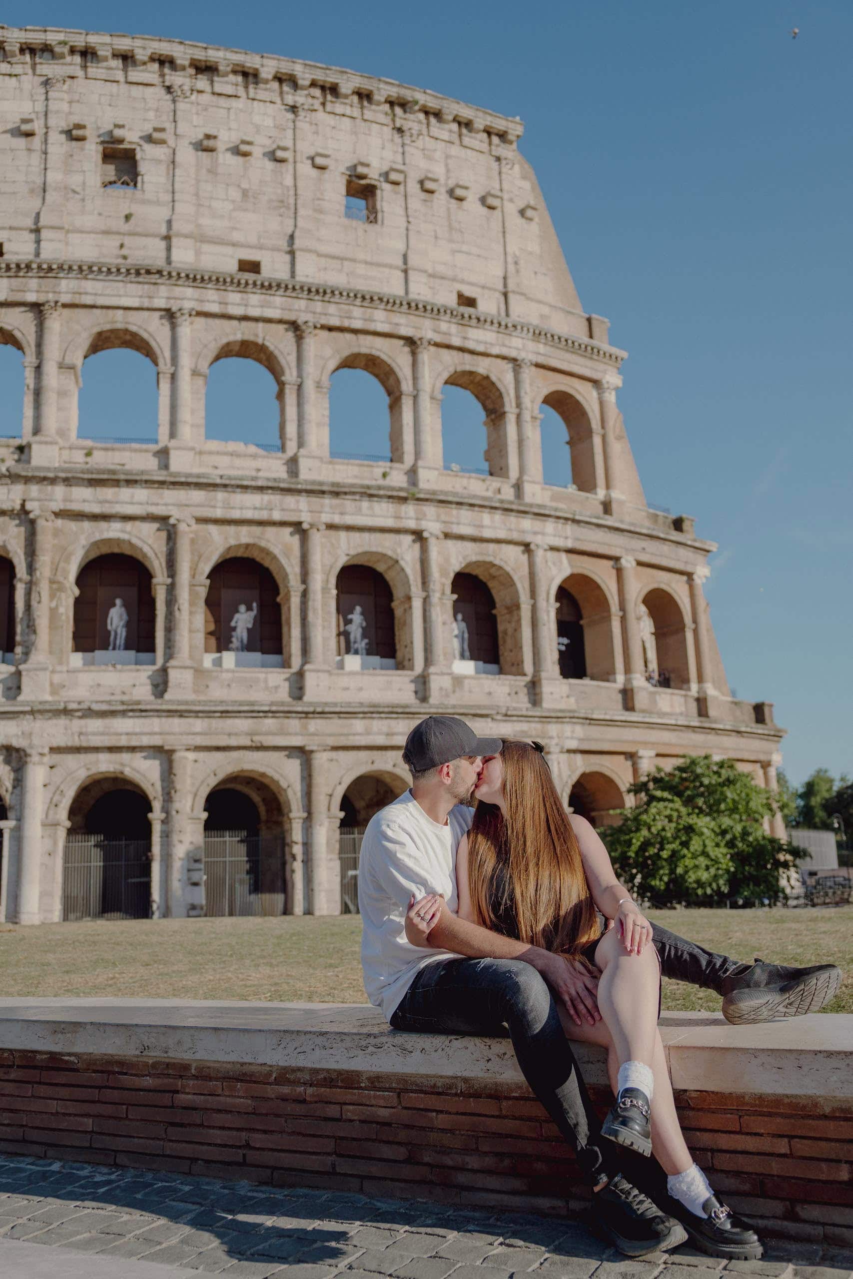 Couple kissing seated colosseum Rome - couples photography in Rome by Finzi
