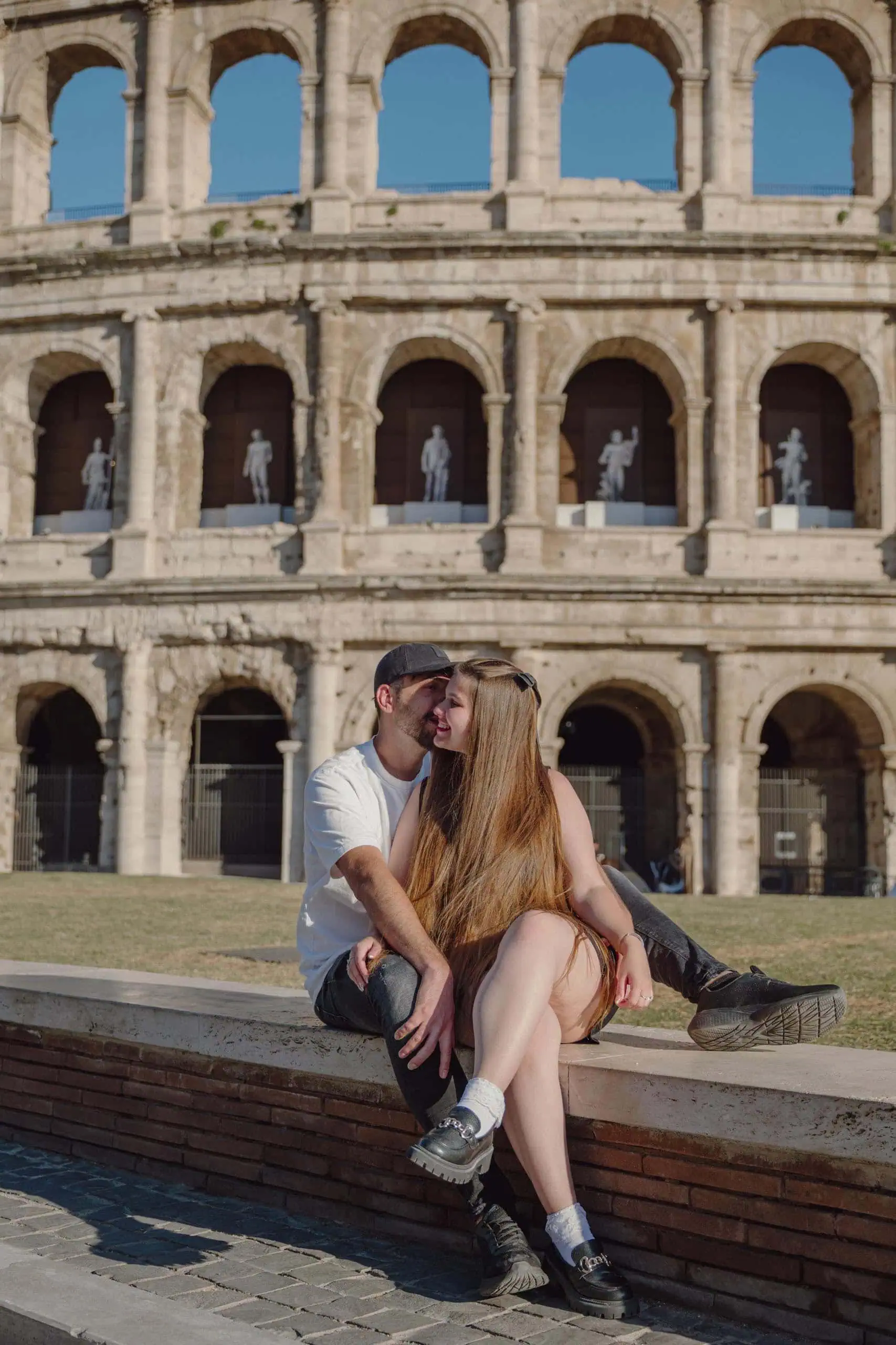 Couple sitting kissing colosseum statue arches Rome - Rome by Finzi