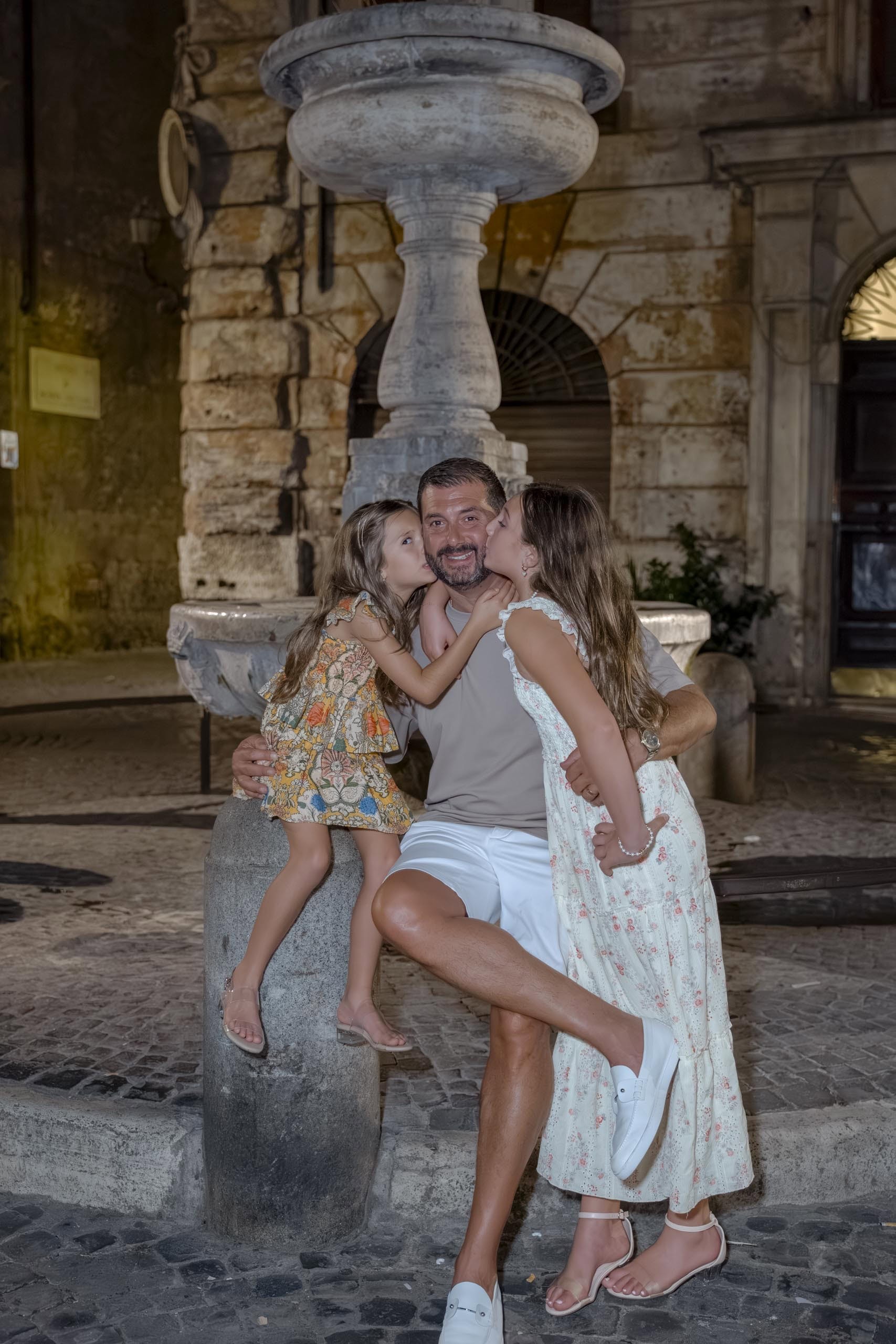 Father two daughters kiss fountain Rome - families photography in Rome by Finzi