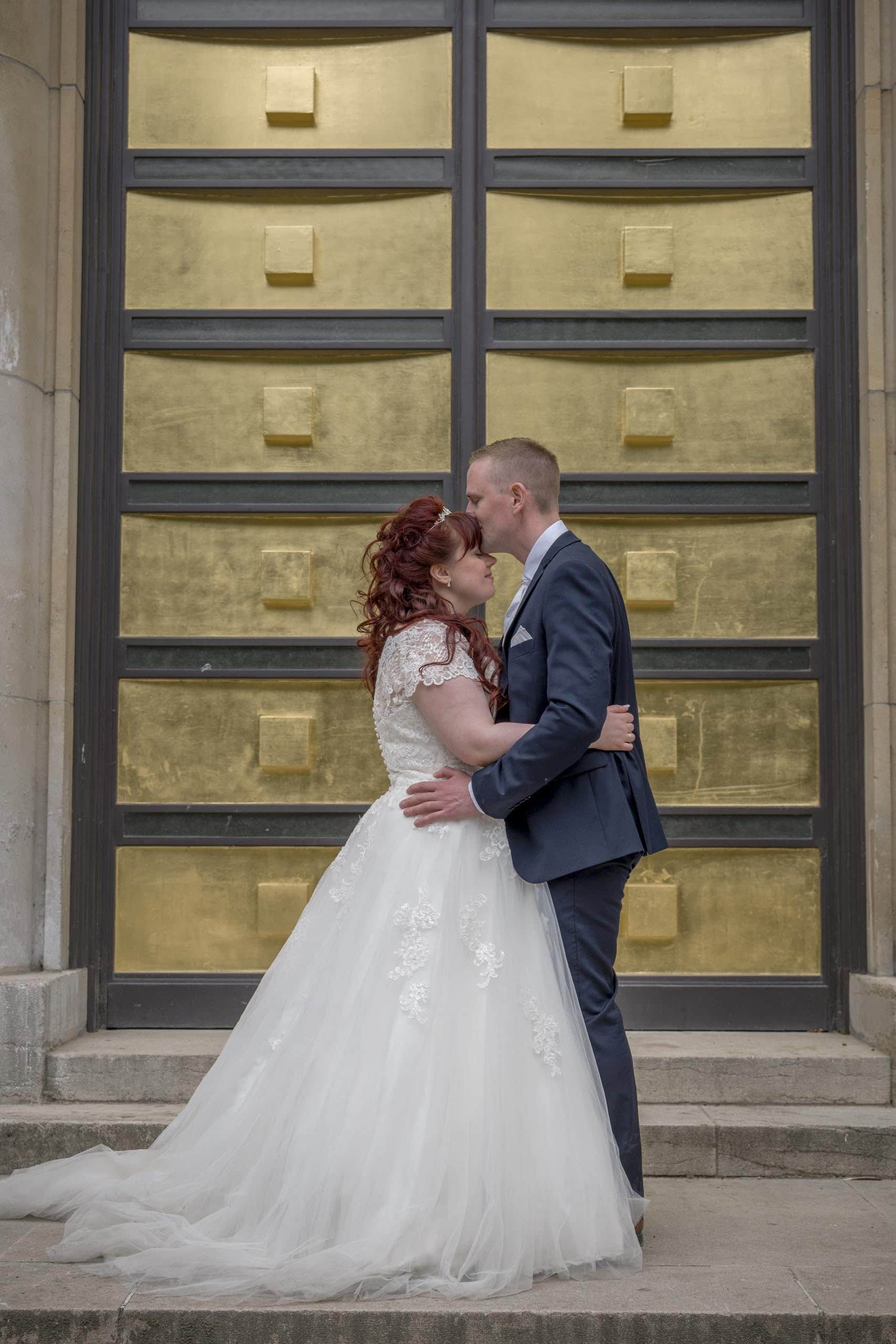 Groom forehead kiss golden doors Rome - weddings photography in Rome by Finzi